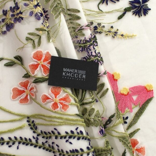 Green, purple and pink Tulle fabric adorned with floral embroidery