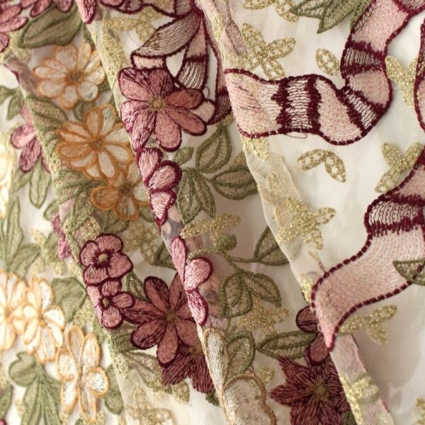 Light beige and burgundy coloured Tulle fabric adorned with floral embroidery