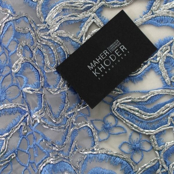 Blue Tulle fabric adorned with enormous and tiny floral embroidery
